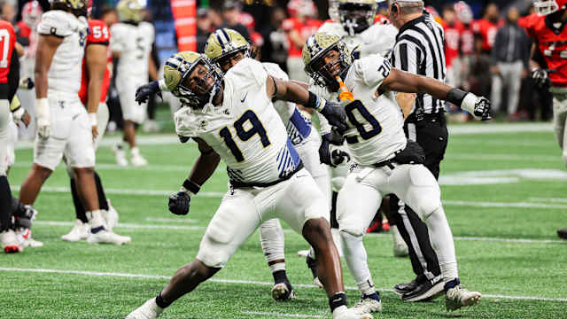 Thomas County Central's Walter Reddick (19) and Caleb Anderson (20) celebrate another big play by the Yellow Jackets roster. The two combined for 2-1/2 of the team's 10 sacks. 12/12/2023